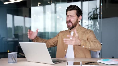 Man Frustrated at Computer During Video Call