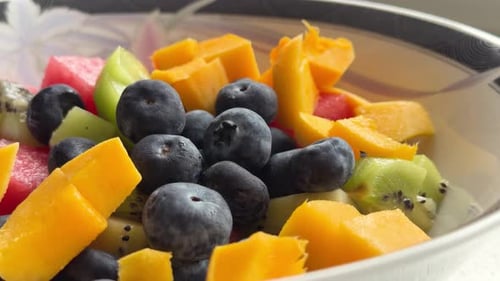 Nahaufnahme von frischem Obstsalat mit Blaubeeren, Mango, Kiwi und Wassermelone