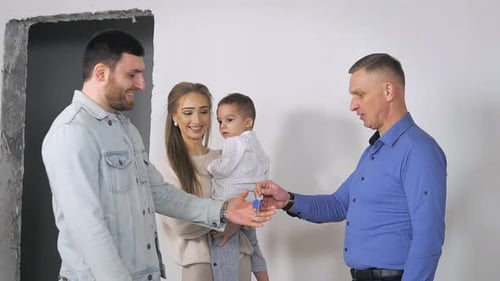 A Real Estate Agent Shows a New Apartment Without Renovation in a New Building to a Young Beautiful