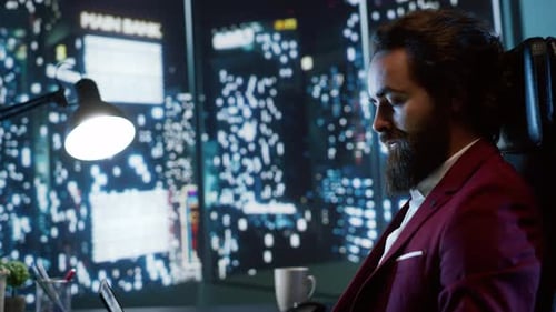 Man Works Late with Cityscape View