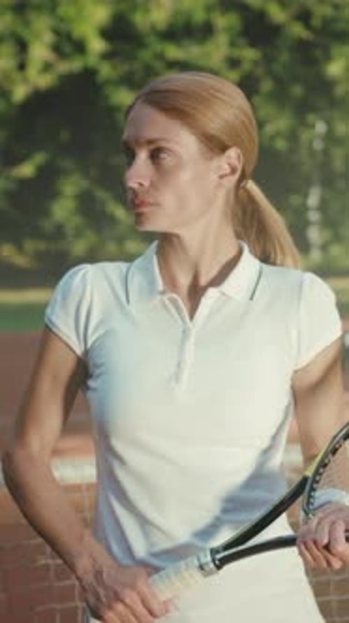 Athlète de tennis pratiquant une athlète féminine qui se concentre intensément tout en se préparant pour le service sous un soleil ensoleillé