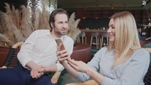Close Up Young Happy Couple with Smartphone in Cafe Talking Smiling Sitting Have Conversations