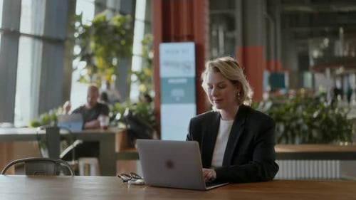 Konzentrierter Profi, der sich mit der Arbeit am Laptop in Modern und Workspace beschäftigt