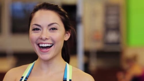 Smiling woman in gym attire looks at camera