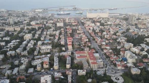 Aerial Shot Of Buildings And Harbor In City, Drone Flying Backwards Over Residential Structures
