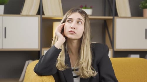 Thoughtful Woman Ponders While Resting on Couch