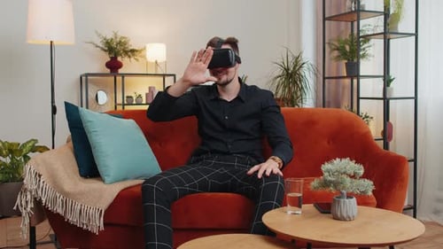 Young Man Using VR Headset on Sofa