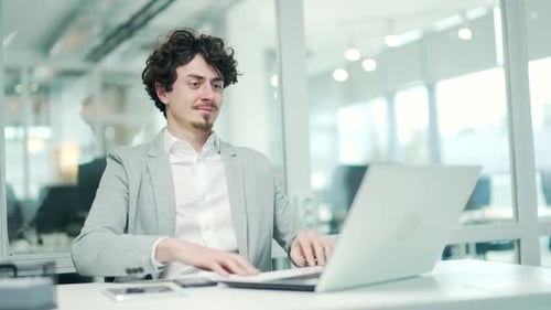 Man Working on Laptop Celebrating Success in Office