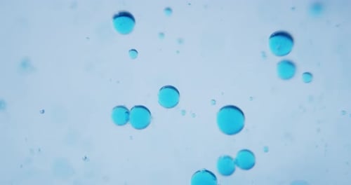 Slow motion macro of micro particles molecules in a liquid are analyzed with microscope for bioche
