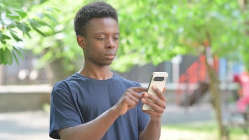 Young Adult Using Smartphone in Urban Park