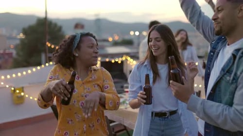 Young Adults Enjoying an Outdoor Party At Sunset