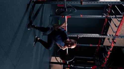 vertical video young motivated bodybuilder squatting with heavy barbell in gym exercise active