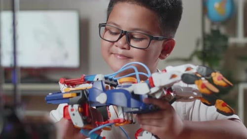 Close Up Of Asian Cute Boy Looking At Checking A Cyborg Hand At Home