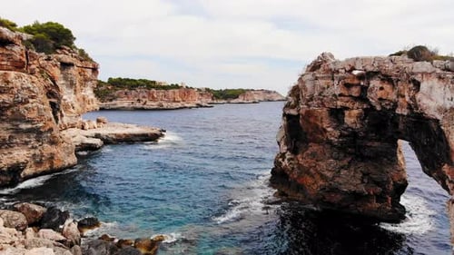 Aerial shot of Es Pontas famous natural arch and cliffs in the south east coast of the Island of Mal