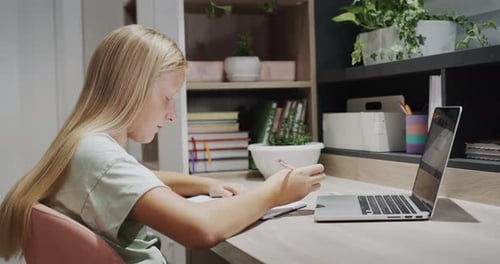 Girl Studying Using Laptop and Writing in Notebook