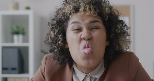 Retrato em loop de uma empresária afro-americana brincalhona fazendo caretas olhando para a câmera em