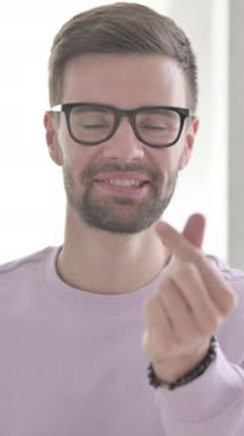 Man with Beard Smiling and Makes Finger Heart Gesture