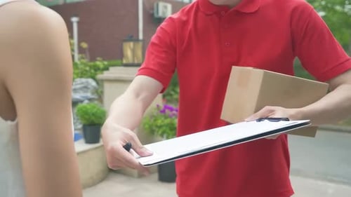 Delivery man Uniform smiles during express, courier holding a small package parcel Delivering goods