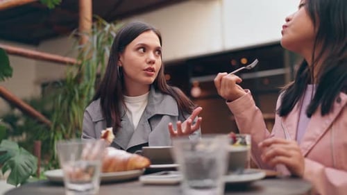 Diverse Friends Chatting Over Brunch at Cozy Cafe