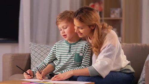 Young Boy Drawing with Mother at Home