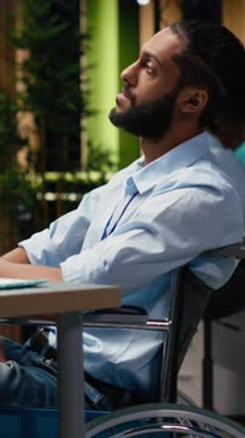 Vertical Video Arab Wheelchair User Engaged in Strategic Thinking During Late Night