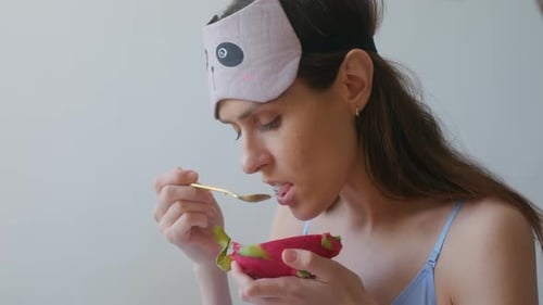 Woman Eats Dragon Fruit With Spoon Indoors