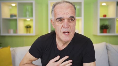 Der alte Mann, der es satt hat zu schwitzen. Er wischt sich den Schweiß mit der Hand ab und ist überwältigt.