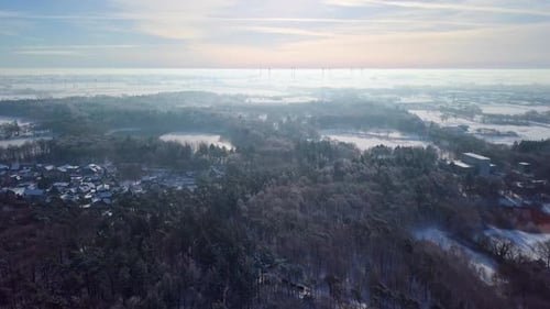 Aerial View Of Snowy Village With Dense Forest At Wintertime.