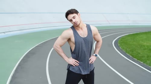 Muscular Man Stretching on Track in Gray Tank Top