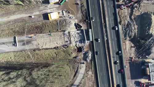 Static drone shot of a construction site and highway next to eachtoher