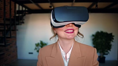 Woman smiling while using a Virtual Reality headset in an office