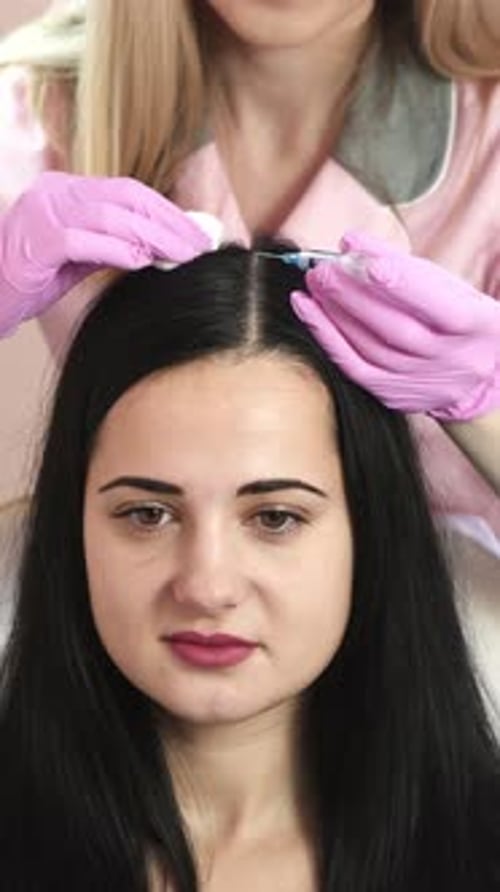 Needle mesotherapy. cosmetologist makes injections in woman head