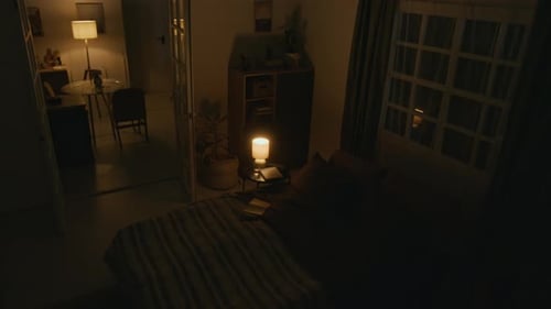 Interior of Bedroom Illuminated by Lamps at Late Night while Lightning Flashes