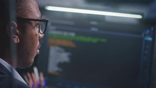 African American Software Engineer Looks at Computer Screen