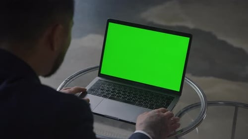 Businessman Working on Laptop with Green Screen
