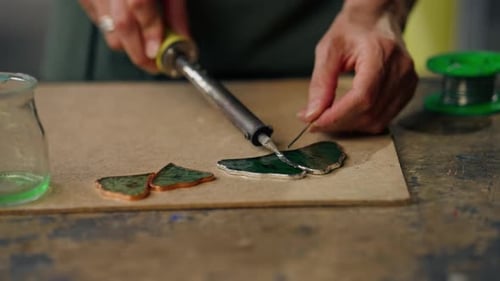 Close Up in a Large Green Workshop on a Woman with Green Hair Creates Decorative Flowers Working