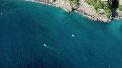 Aerial Top Down View of a Small Boat Sailing in Turquoise Mediterranean Sea Water.