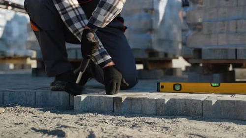 Construction Worker Installing Gray Concrete Pavers