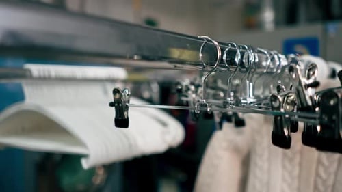 Close Up Professional Dry Cleaning Stand with Different Textile Clothes on Hangers