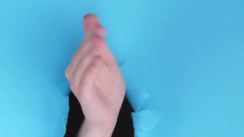 Hand Giving Thumbs Up Through Blue Paper
