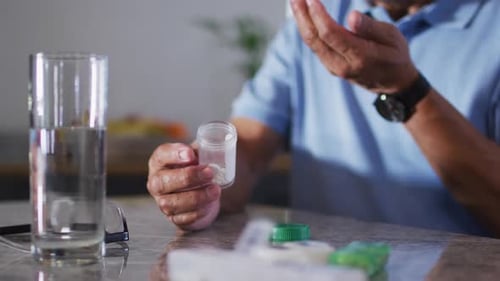 Adult Taking Medicine at Home with Water