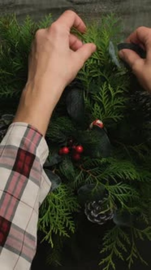 Vertical Video Woman Puts Centerpiece Christmas Floral Decoration on Table