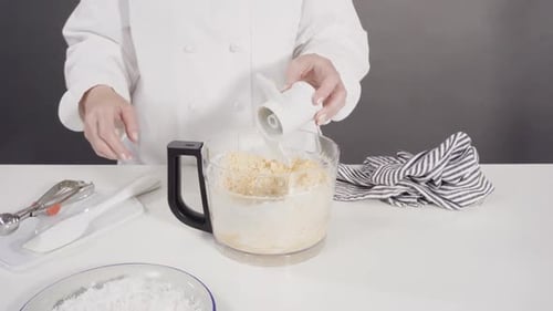 Mischen von Zutaten in einer Küchenmaschine, um hausgemachte Kokosnusskekse zuzubereiten