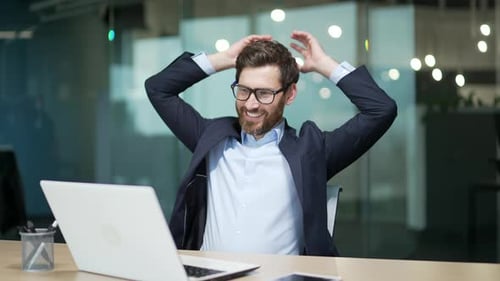 Successful Man Celebrates Finishing Work in Office
