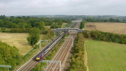Intercity-Zug, der auf einer Eisenbahnstrecke auf dem Land vorbeifährt.