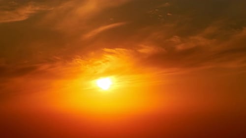 Eine große rote Sonne am Himmel bei Sonnenuntergang, eine Sommerlandschaft. Abendhimmel bei heißem Sonnenlicht