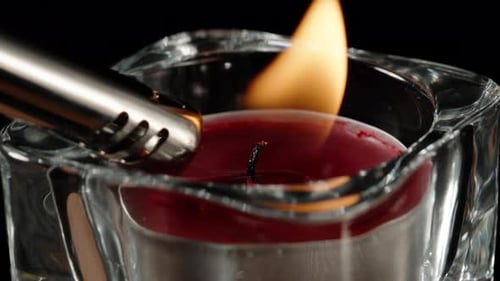 I light a red candle in a glass candlestick, Close-up.