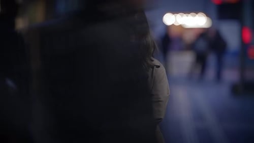 A Pensive Woman in a City at Night Immersed in Contemplation Amidst Urban Lights