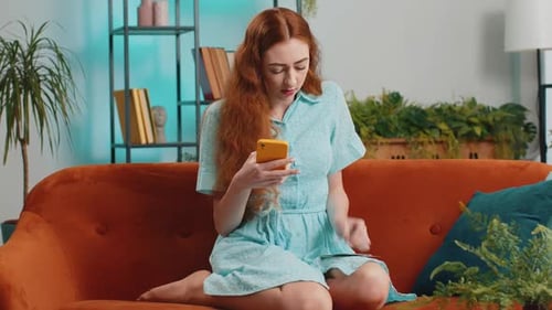 Woman Uses Phone, Counts Money on Sofa