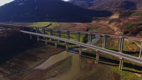 Bridge spans a river in a dry landscape during daytime hours
